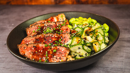 Beautiful oriental bowl with thin slices of rare sirloin, edamame, sunomono salad, and teriyaki sauce. Vibrant colors, fresh ingredients, perfect for a healthy and gourmet meal.