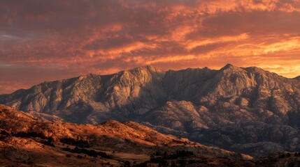 Obraz premium Majestic Mountain Range Bathed in Golden Sunset Light.