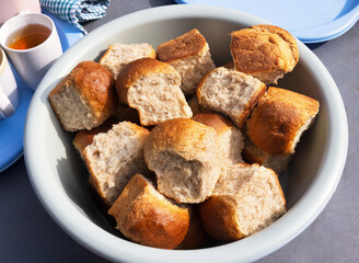 bowl of freshly made, Mapakiwa rolls in Botswana, whole wheat baked bread rolls, African tea buns, and mugs with tea