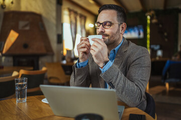Man enjoying coffee break in cafe with laptop