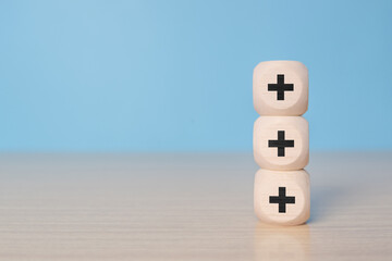Plus sign in wooden cube block stacking. Addition and positive mindset thinking such as profit, benefits, development, CSR represented, motivation, increase concept and copy space.