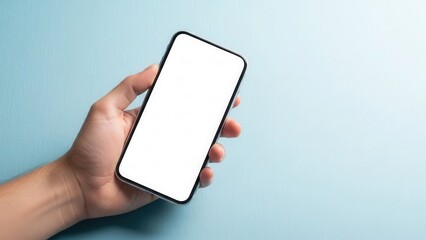 Hand holding smartphone with empty white screen over light blue textured background