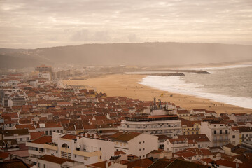 Panoramic View of Coastal Town and Sandy Beach at Sunset.