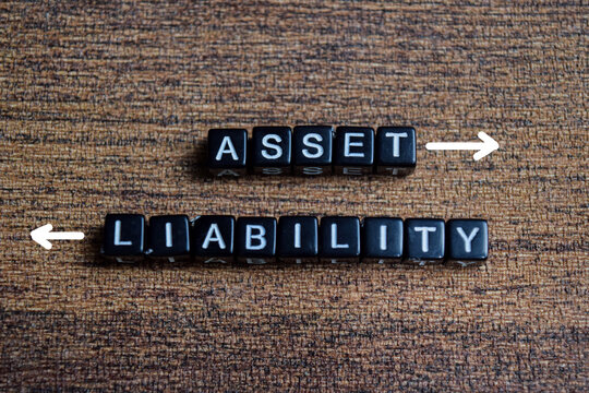 Concept of asset and liability words arranged with on wooden letter blocks.