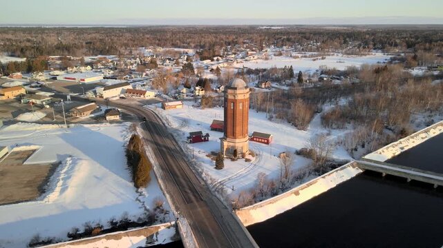 Aerial view of tall historic Manistique water tower at Manistique River in Michigan upper peninsula in winter time
