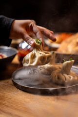 Hand Picking Hot Georgian Khinkali Dumpling At Restaurant