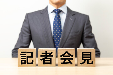 「記者会見」と書かれたブロックとビジネスマン
