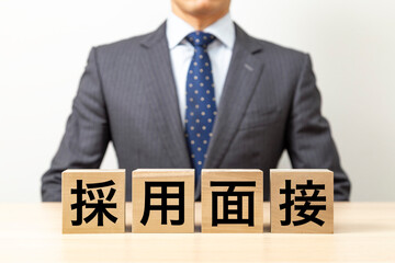 「採用面接」と書かれたブロックとビジネスマン