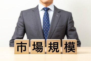 「市場規模」と書かれたブロックとビジネスマン