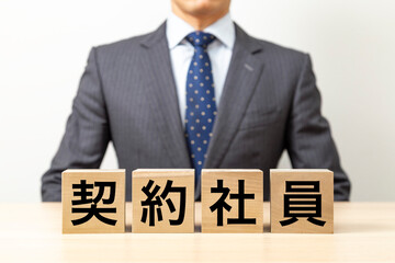 「契約社員」と書かれたブロックとビジネスマン