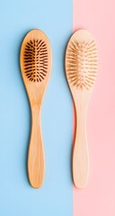 Minimal flat lay of wooden hairbrushes on soft pastel background.
