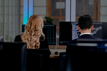 Intense coding workflow: Two software developers deeply focused on programming complex algorithms, side-by-side on dual monitors. A glimpse into modern software engineering life.