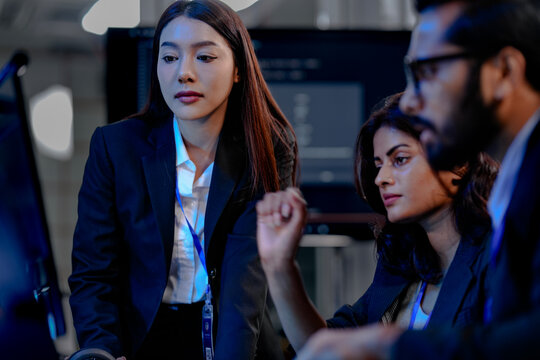 A lead data analyst points out a critical insight on a dashboard to his two female colleagues, reviewing complex datasets and visualizations for a business intelligence report. - Powered by Adobe