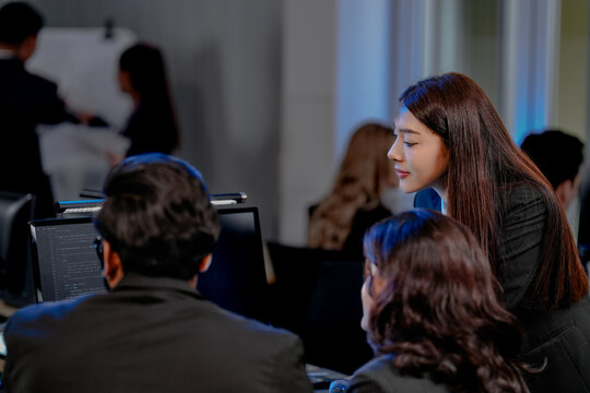 A strategy team reviews predictive analytics generated by an AI platform. The lead points to a forecast, guiding the team in making a critical, data-driven business decision. - Powered by Adobe