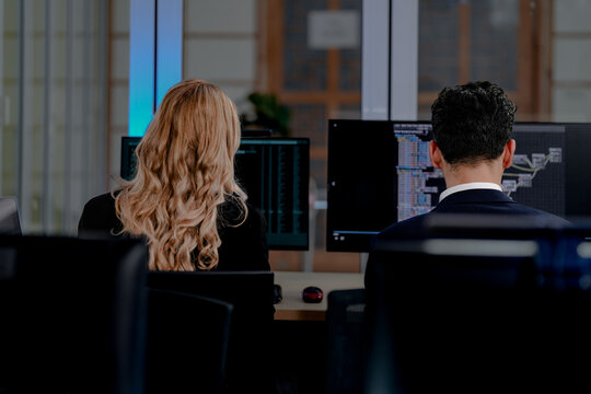 Intense coding workflow: Two software developers deeply focused on programming complex algorithms, side-by-side on dual monitors. A glimpse into modern software engineering life.