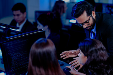 A strategy team reviews predictive analytics generated by an AI platform. The lead points to a forecast, guiding the team in making a critical, data-driven business decision.