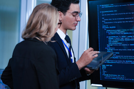 Monitoring AI training progress. Specialists oversee a machine learning model's training observing real time metrics on screen discussing adjustments via tablet interface late night. - Powered by Adobe