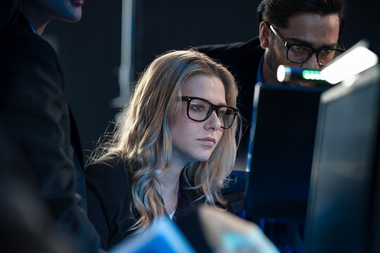 Night watch cybersecurity team collaborates intensely Diverse analysts monitor multiple screens tracking active threats protecting critical infrastructure vital digital defense activated now. - Powered by Adobe