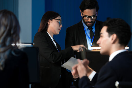 Data integrity check night shift Diverse team meticulously audits financial performance comparing figures tablet screen printed reports ensuring accuracy crucial validation process underway hub. - Powered by Adobe