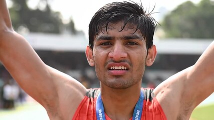 Young adult Asian athlete with medal. Achievement, sports success, winning and competition concept.