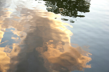 Golden Cloud Reflections on Calm Water Surface