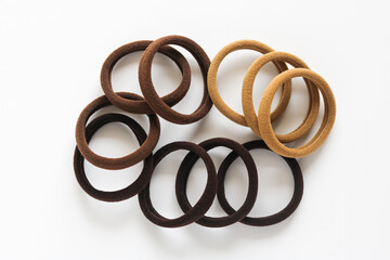 A bunch of elastic, fabric-covered hair ties, placed against a white background, showcasing the simple texture of the everyday accessory.