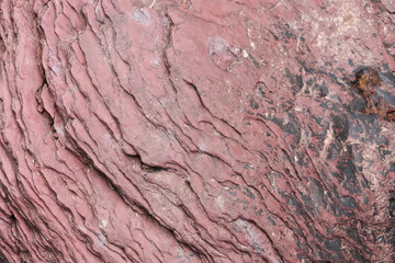 Detailed rough pink stone texture background with natural geological pattern and sturdy layered rock surface showing organic erosion marks and ancient abstract design
