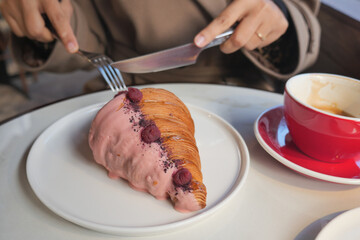 Enjoying a croissant with coffee at a cafe