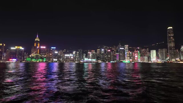 Time-lapse video of the iconic Hong Kong skyline and Victoria Harbour at night with a passenger boat passing by