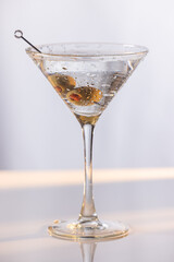 Beautiful and refreshing Martini with two olives with play in the highlights and shadows and color temperatures.