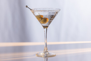 Beautiful and refreshing Martini with two olives with play in the highlights and shadows and color temperatures.