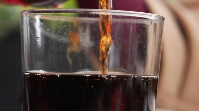 Pouring soft drinks into a glass at a restaurant table