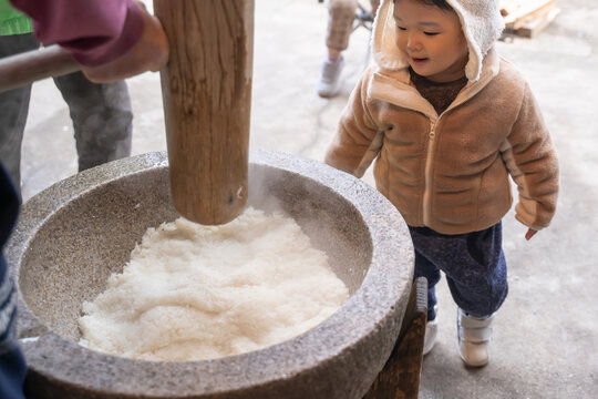 お餅つきを笑顔で楽しむ赤ちゃん