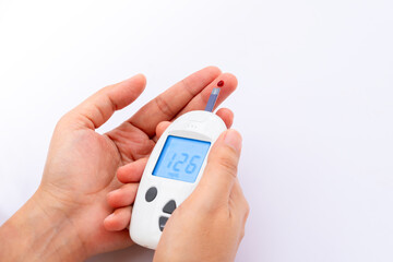 Woman's hands checking diabetes and hyperglycemia with digital blood sugar meter. Healthcare and medical concept	