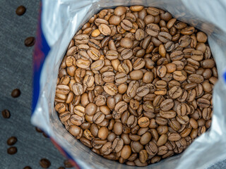 Opened package of coffee beans. Top view of golden coffee beans. Coffee prices and their changes