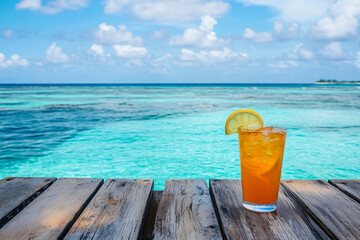 Refreshing Tropical Drink on Wooden Table Overlooking Azure Ocean