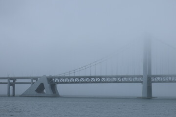 Fototapeta premium aerial view of a long bridge on a foggy day, hazy, transporation over water