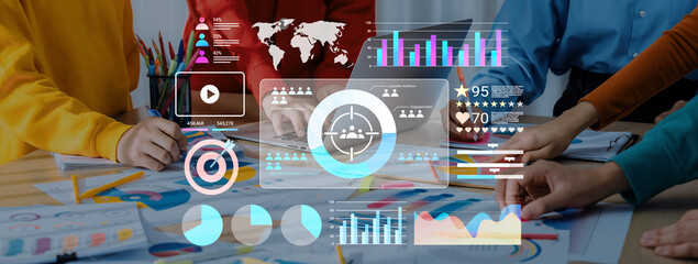 A dynamic business meeting featuring diverse professionals analyzing digital charts and infographics, showcasing teamwork and data-driven decision-making in a modern office environment. Gantry