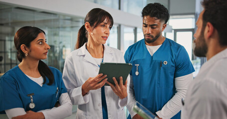Tablet, discussion and doctors with nurses in hospital for medical report, research or feedback....
