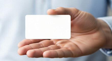 Close-up of a hand presenting a pristine, blank white card, ideal for custom text or design, perfect for showcasing business information, personal identity, or a new concept