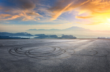 Empty asphalt road square and beautiful sea with mountain landscape at sunset