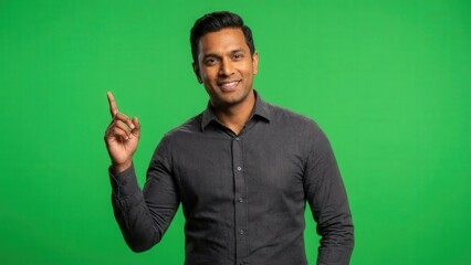 smiling confident man in casual shirt gesturing upward against vibrant green background
