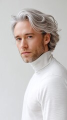 A man with flowing silver hair in a minimalist turtleneck staring at the camera with calm intensity in a white studio setting. 