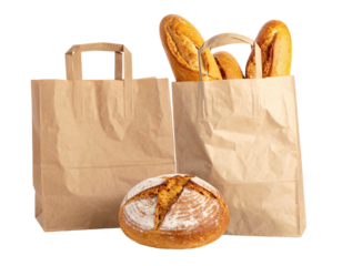 Paper bags holding loaves of bread on a black backdrop