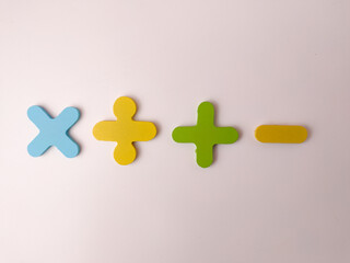 Obraz premium The image displays wooden or foam cutouts of basic mathematical operation symbols