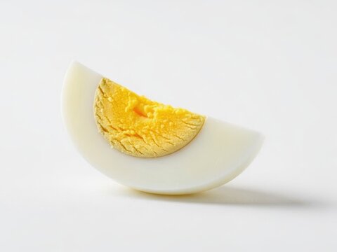 Perfectly cooked hard-boiled egg quarter with a bright yellow yolk on a clean white background