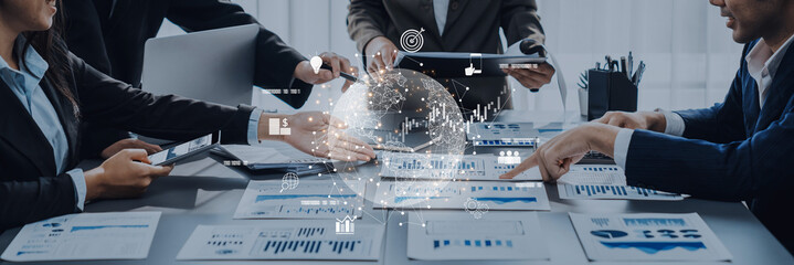 A diverse business team engages in data analysis in a modern office, focusing on charts and digital graphs to drive strategic planning and informed decision making. Trope