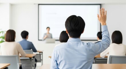 Obraz premium A young professional seated at a modern desk in a minimalist conference room raises their hand