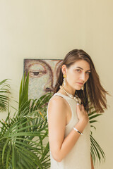 The portrait of beautiful brunette woman closeup on the green natural background with decorations. bali, indonesia