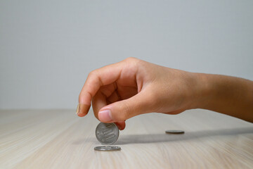 Hand Stacking Japanese 100 Yen Coins on Wooden Table